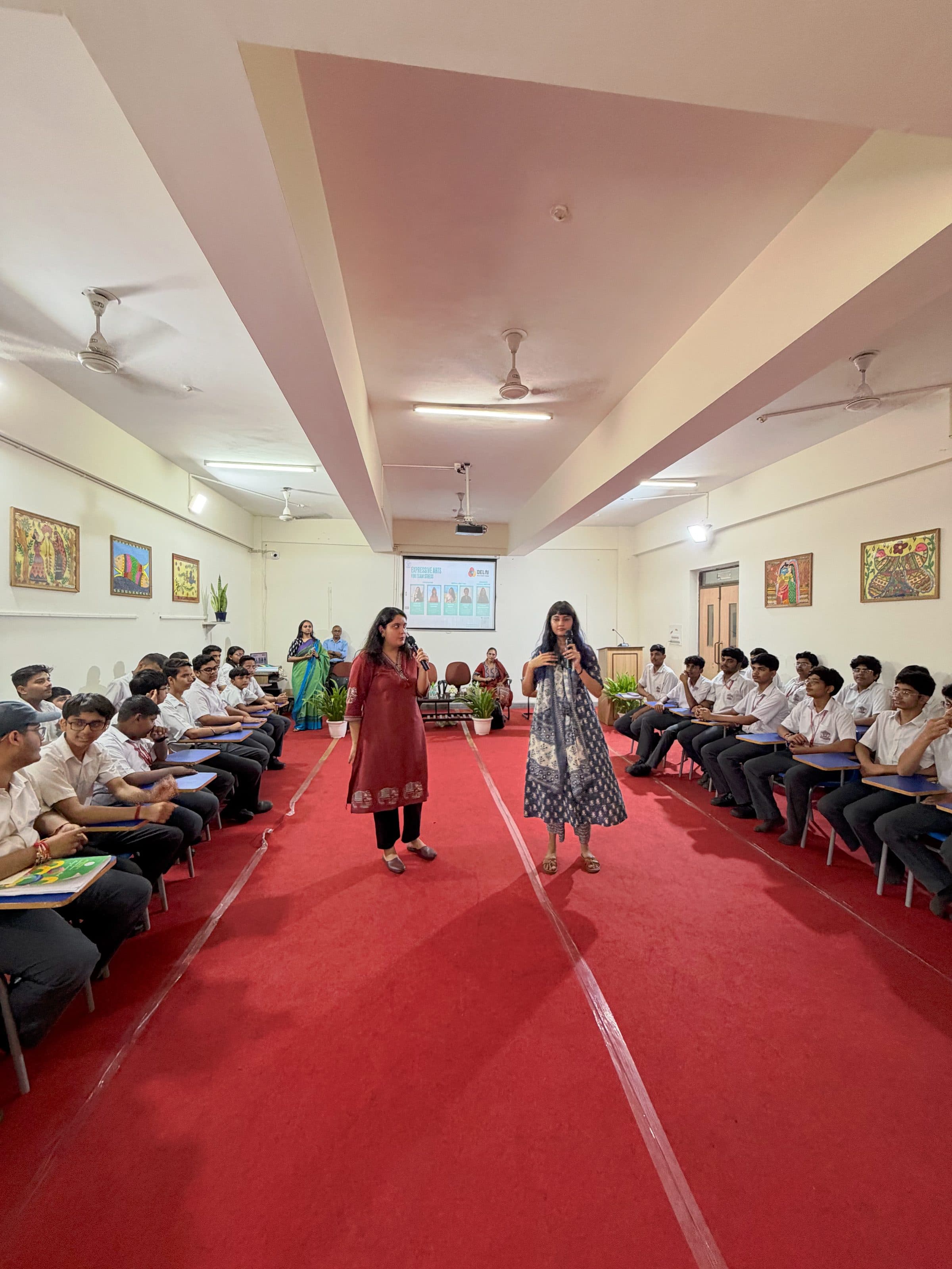 Two facilitators speaking to rows of students in a school hall during the Navigating Exam Stress session at Jagran Public School