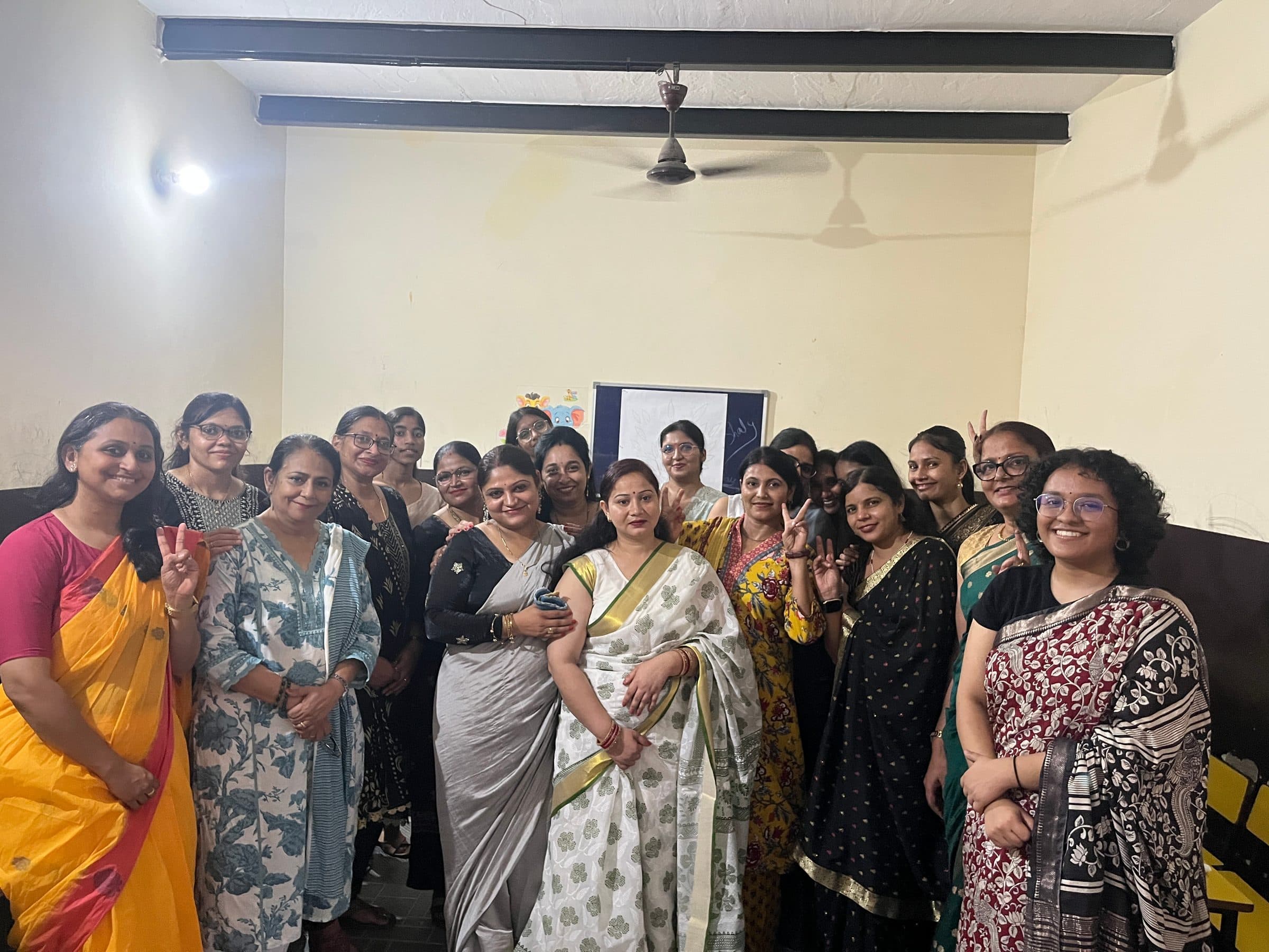 A group of teachers posing together and smiling in a classroom after the wellness event